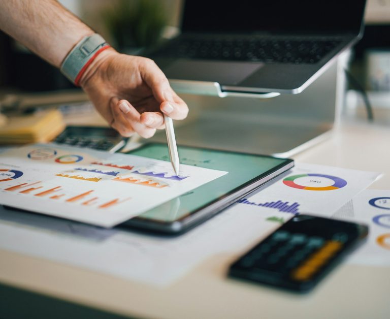 Reviewing business performance charts with a laptop and calculator